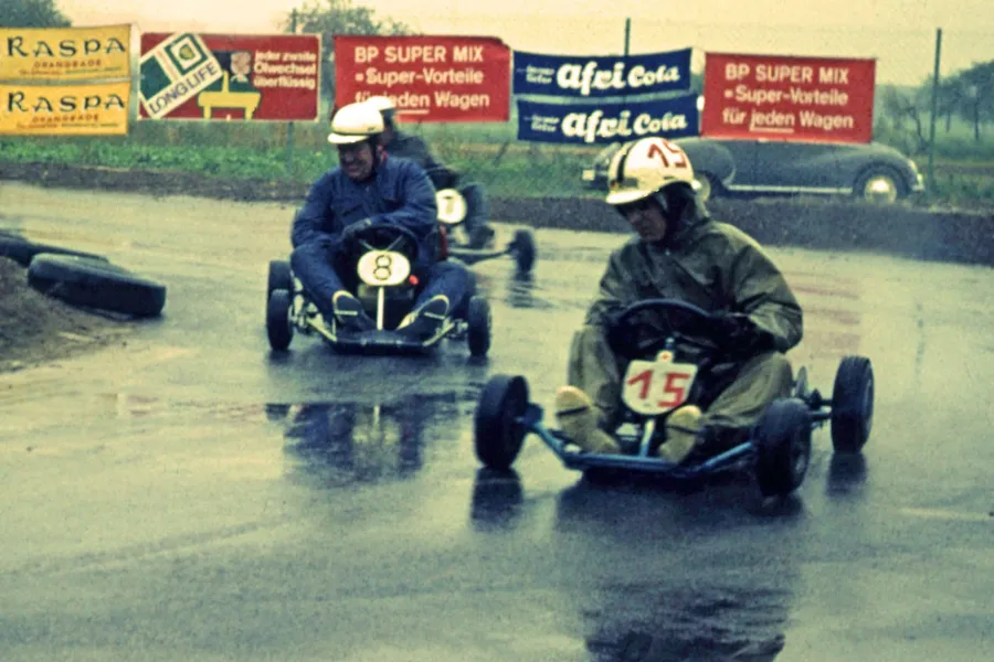 Historisches Farbfoto: Kartfahrer im Regen auf der Kartbahn, 1964.