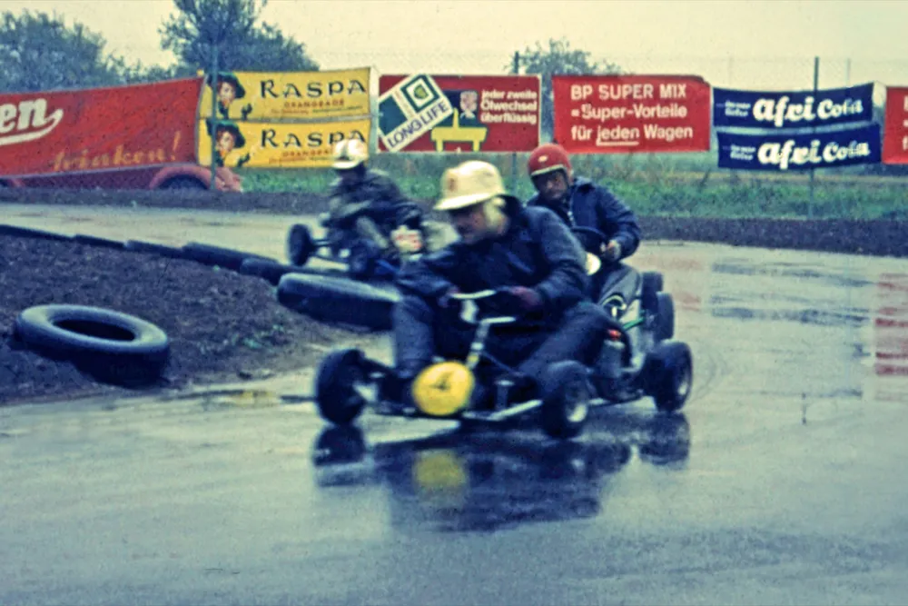 Historische Aufnahme: Kartfahrer im Regen auf der Kartbahn, 1964.