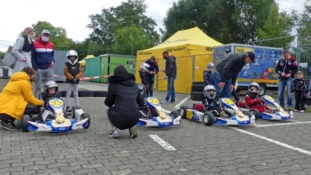 Helfer und Fahrer kümmern sich im Fahrerlager beim Kartrennen um die Karts.