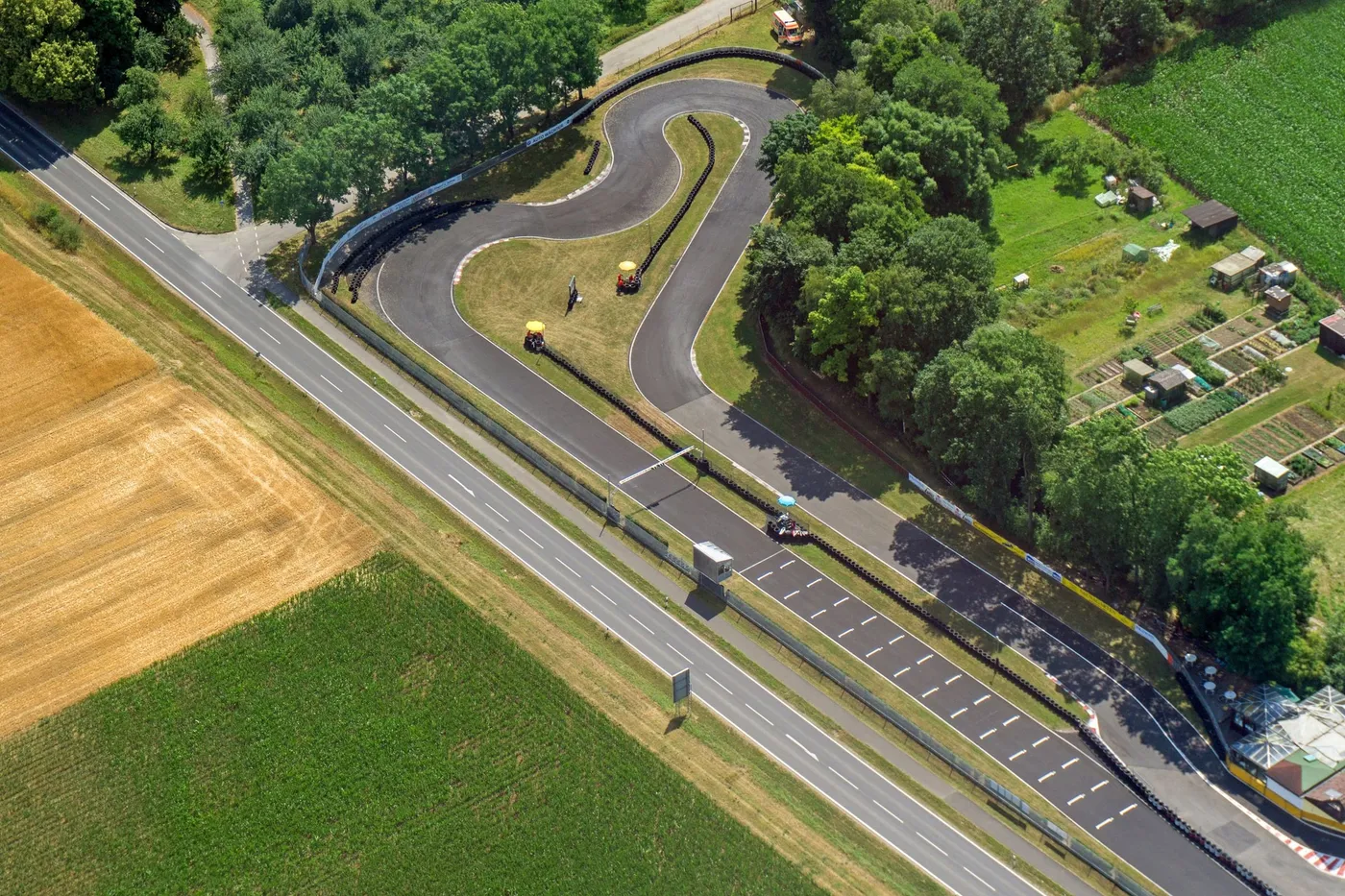 Luftaufnahme des Steigerwald-Motodroms mit der kurvigen Kartbahn zwischen Feldern und Bäumen.