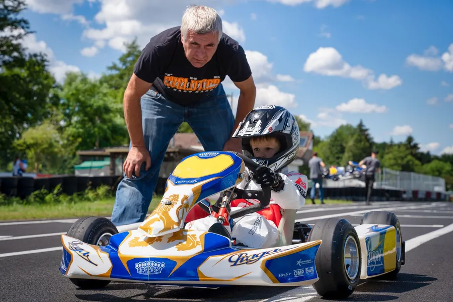 Ein Betreuer hilft einem Kind beim Einsteigen ins Kart.