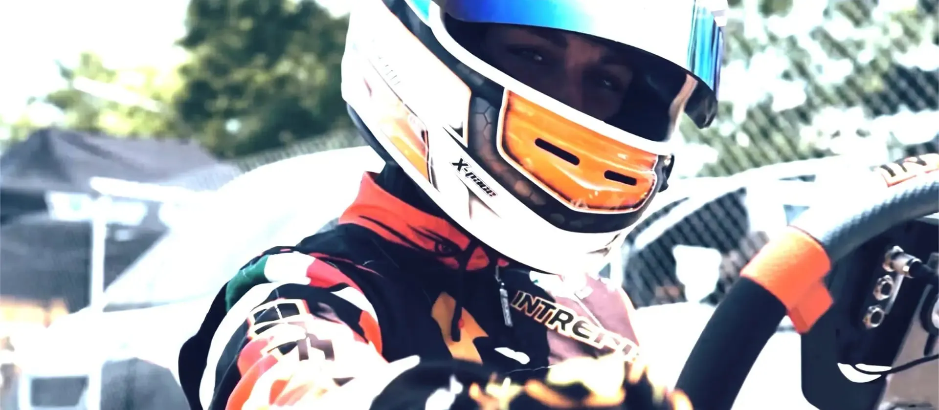 Nahaufnahme eines Kartfahrers mit Helm und verspiegeltem Visier im Kart.
